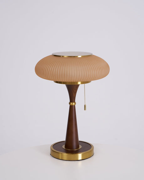 Amber glass cap on a walnut stem, unlit on a plain ground