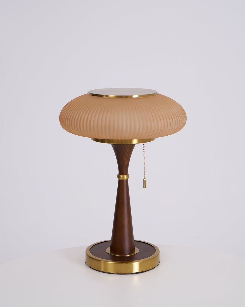 Amber glass cap on a walnut stem, unlit on a plain ground