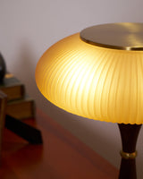 Close view of the lit ribbed glass cap from below the rim