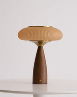 Amber glass table lamp seen in full height against a plain ground