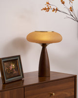 Amber glass table lamp lit on a chest beside a small framed picture