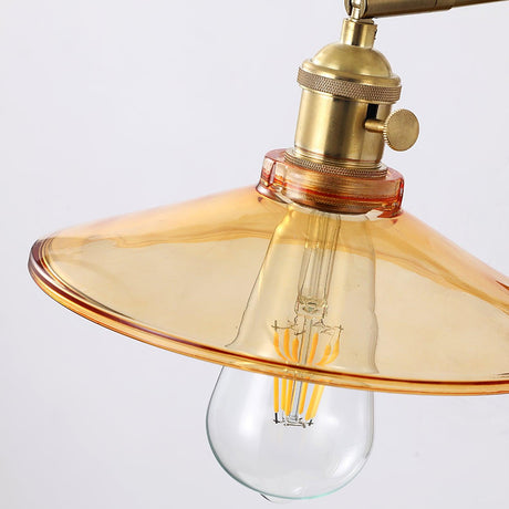 The flared amber glass shade seen from below with the filament bulb