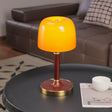 Amber table lamp seen from the front, the tinted dome lit