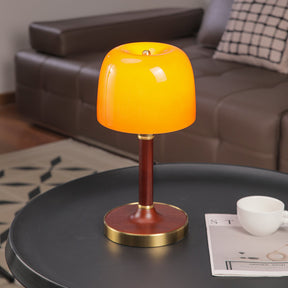 Amber table lamp seen from the front, the tinted dome lit