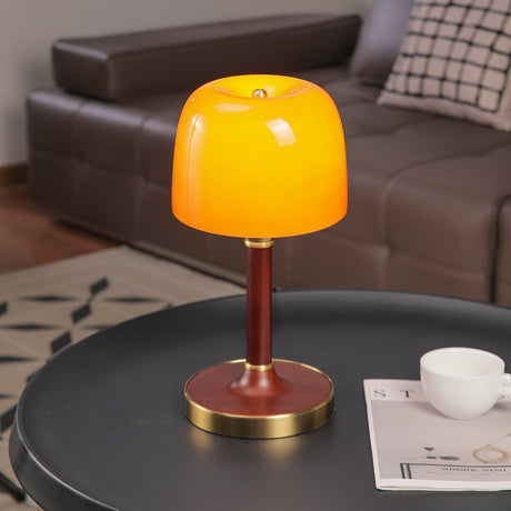 Amber table lamp seen from the front, the tinted dome lit