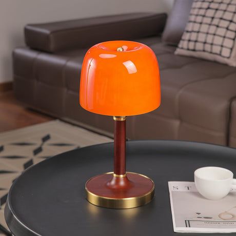Amber table lamp unlit, the deep orange tint of the glass in view