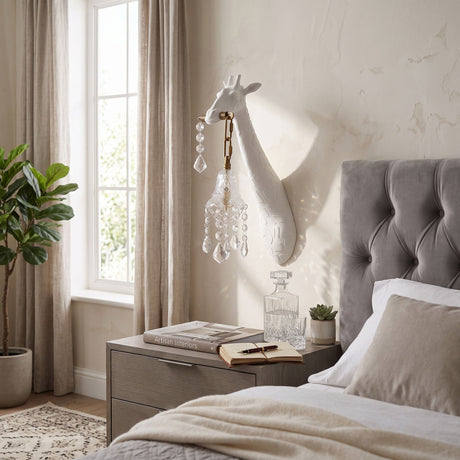 The white giraffe sconce between a window and a tufted headboard in a bedroom