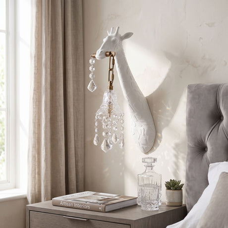 The white giraffe sconce above a nightstand with a decanter beside a gray headboard