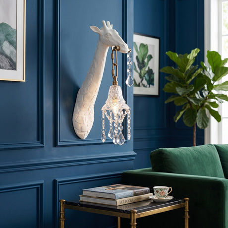 The white giraffe sconce on a blue paneled wall above a side table and a green armchair