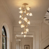 Brass branch chandelier in a pale stairwell with an arched window