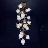 Brass branch chandelier seen full length against a dark blue background