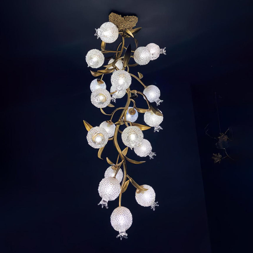 Brass branch chandelier seen full length against a dark blue background