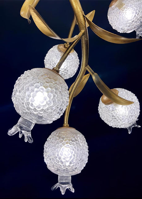 Close view of four frosted globes hanging from their brass stems