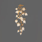 Brass branch chandelier seen full length against a gray background