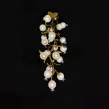 Brass branch chandelier seen full length against a black background