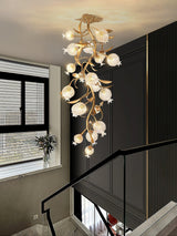 Brass branch chandelier in a stairwell beside a tall window