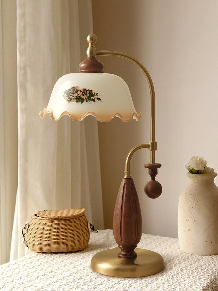 Antique brass table lamp lit beside a woven basket and a vase