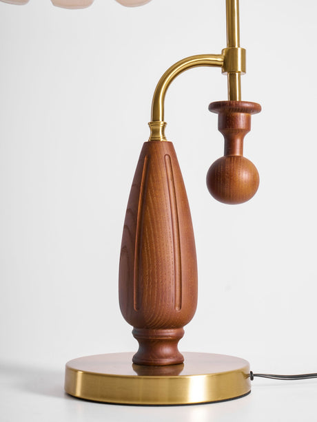 Close view of the round brass foot and the walnut counterweight