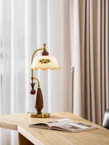 Antique brass table lamp on a desk by a window with an open book