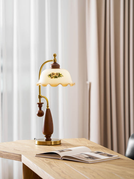Antique brass table lamp on a desk by a window with an open book