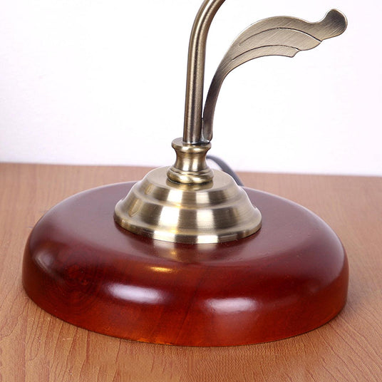 Close view of the round cherry wood base and the brass collar