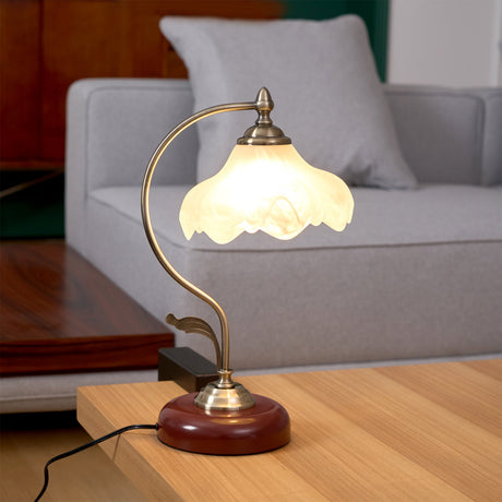 Flower shade lamp lit on a side table beside a pale gray sofa