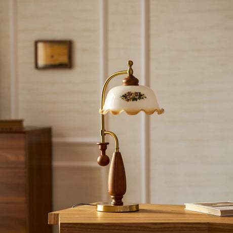 Antique brass table lamp lit on a desk in a wood lined study