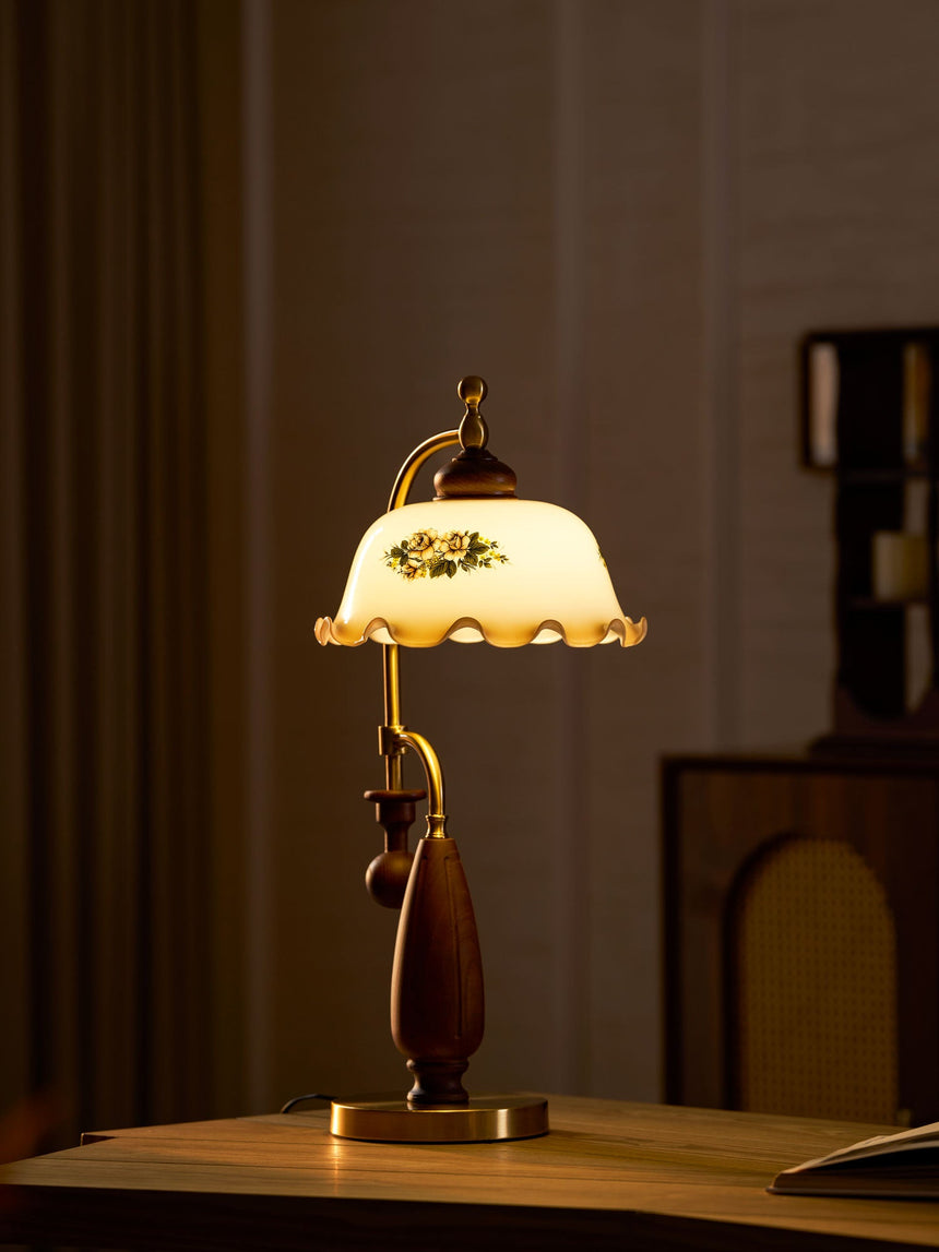 Antique brass table lamp lit on a table in a dim room