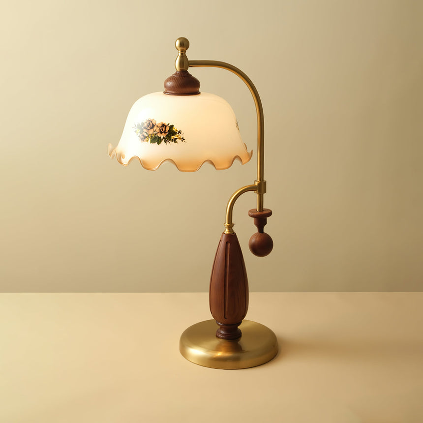 Antique brass table lamp lit against a plain warm ground