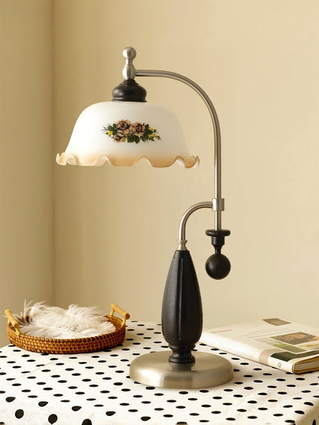 Antique brass table lamp lit on a table with a patterned cloth