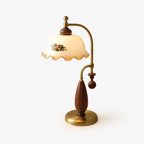 Antique brass table lamp with an arched arm and a painted glass shade