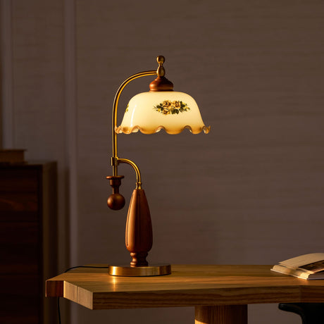 Antique brass table lamp unlit on a wood desk beside a chair