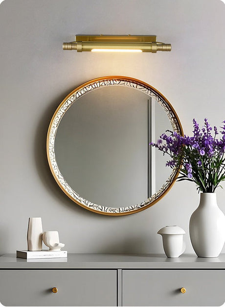 Brass tube above a beaded mirror on a console with lavender and vases