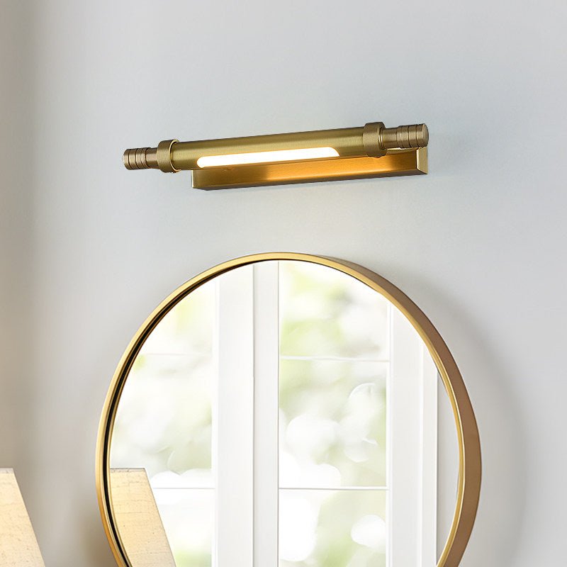 Brass tube lit above a round gold mirror reflecting a bright window