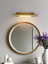 Brass tube above a beaded mirror with white vases on the counter below