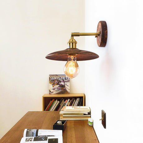 Sconce lit above a low bookcase stacked with books and magazines
