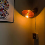 The sconce lit at night, warm light spilling down the wall below it