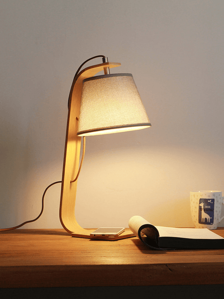 The arc lamp lit close up, the shade hanging from the curve of the arm