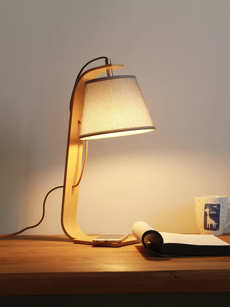 The arc lamp lit close up, the shade hanging from the curve of the arm