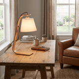 Arc lamp lit on a wood coffee table beside a mug and a book