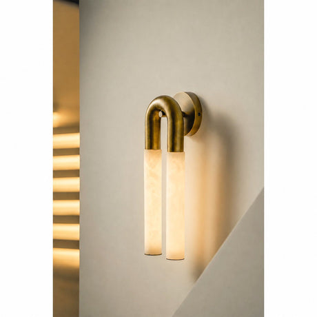The stone tubes glowing warm against a wall with striped light