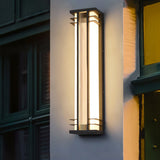 The light on a wall beside a dark green paneled door and a yellow wall