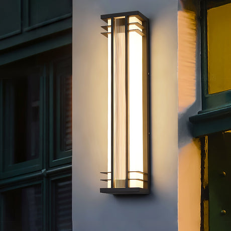 The light on a wall beside a dark green paneled door and a yellow wall