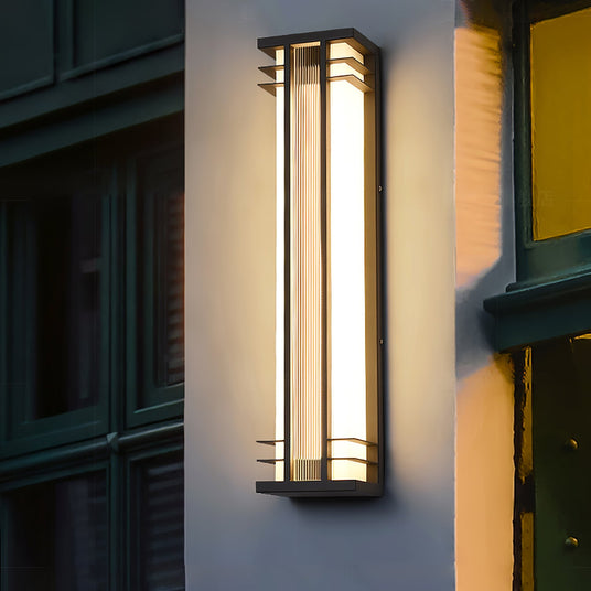 The light on a wall beside a dark green paneled door and a yellow wall