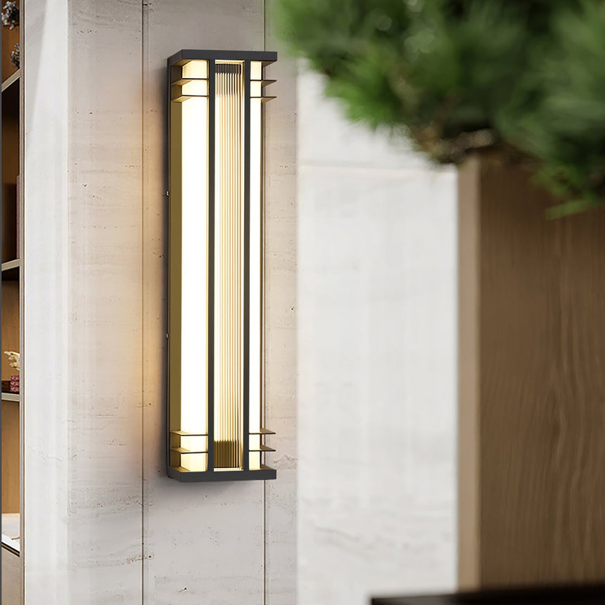 The light on a pale wall beside a timber planter with clipped shrubs