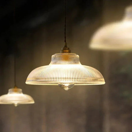 Amber prismatic shade lit under a dark painted ceiling in a dim room