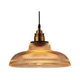 Amber prismatic glass shade with a brass top on a plain gray background