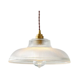 Clear prismatic glass shade with a brass top on a plain gray background