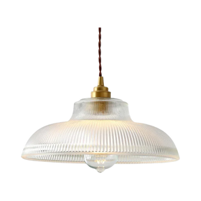 Clear prismatic glass shade with a brass top on a plain gray background