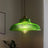 Dark green prismatic glass shade with a brass top on a plain gray background
